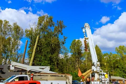 Utility maintenance is progress with technician on lift power lines a Stock Photos