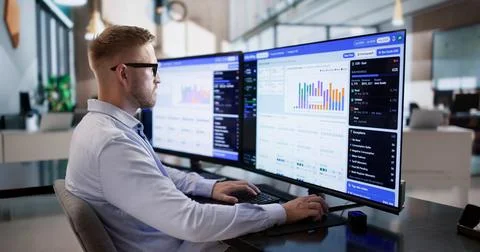 Utility Manager Analyzes Customer Billing Data On Desktop Computer Thoughtful Foto stock