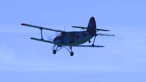 Utility Plane Antonov AN-2 Flying Away into Blue Sky Tracking Shot Stock Footage 332324558