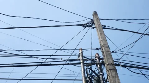 Utility Pole and Overhead Power Lines Viewed From Below Against Clear Blue Sky Stock Footage 339036240