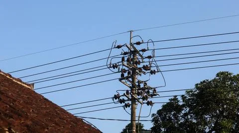 Utility pole with overhead power lines and insulators , set against clear b.. Stock Photos