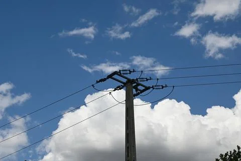 Utility pole with power lines against cloudy sky Фото