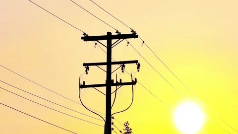 Utility pole power lines silhouette against vibrant yellow sunset sun Video stock 342668122