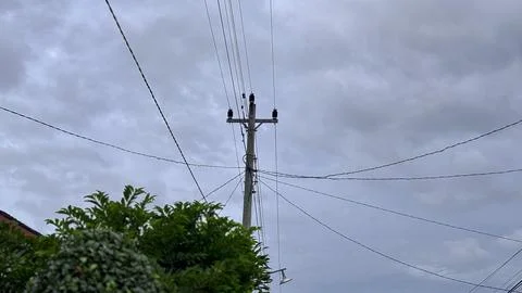 Utility Pole with Power Lines Under Cloudy Sky Stock Photos