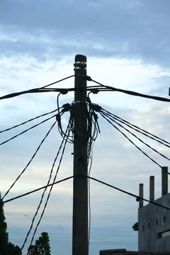 A Utility pole used to support overhead power lines as electrical cables. Stock Photos