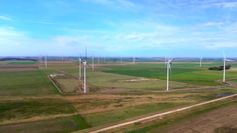 Utility scale wind turbines across cultivated farmland with rural access roads Stock Footage 345983898