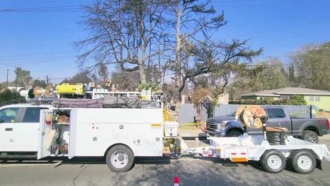 Utility service truck and cable trailer on residential street in Los Angeles Stock Footage 311860449