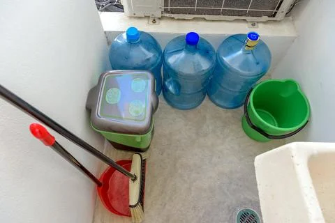 Utility storage area with water containers and cleaning tools Stock Photos