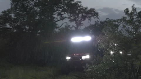 Utility Vehicles Driving in the Rain in the Back Country with Bright Headlights Stock Footage 323404566