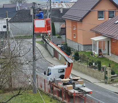 Utility worker in a cherry picker is installing overhead high-speed internet Stock Photos