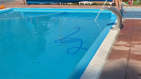 Utility worker cleaning the swimming pool with vacuum equipment Stock Footage 312791916