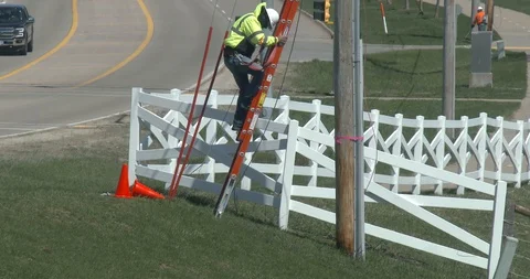 Utility Worker Climbing Down Off a Ladder Stock Footage 128146542