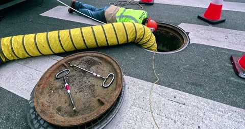 Utility worker conducts maintenance in a street manhole in Los Angeles 스톡 동영상 284017103