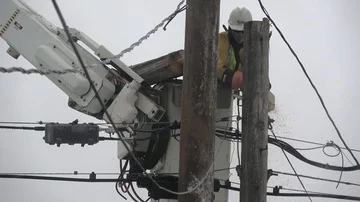 Utility worker cuts off the top of a telephone pole. Stockbeeldmateriaal 85678203