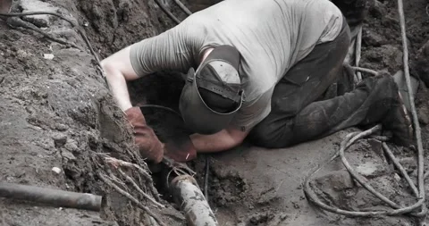 A utility worker eliminates an accident on a pipeline by electric welding Stock Footage 246934469