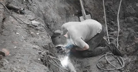 A utility worker eliminates an accident on a pipeline by electric welding Stock-Footage 246934470