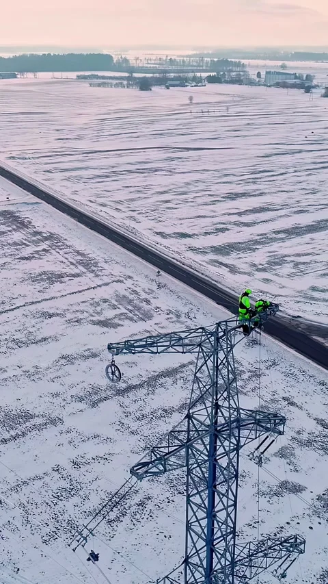 Utility worker inspecting high voltage power lines in winter weather Stock Footage 337016782