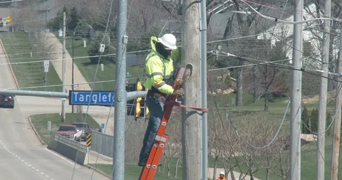 Utility Worker on Ladder - Using Large Drill Stock Footage 128146657