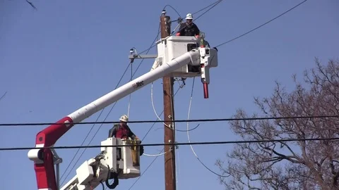 Utility Worker moves cable -2 cherry pickers at pole Stock Footage 105138529