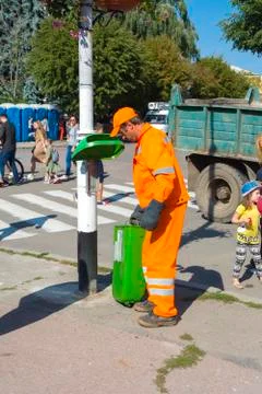 The utility worker removes garbage from the full tank. Day of the city. Zhito Stock Photos