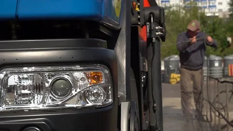 A utility worker washes a garbage truck. Stock Footage 142709537