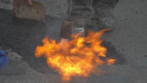 Utility Workers Fixing Gap in a Road by FIlling it with Hot Asphalt 스톡 사진