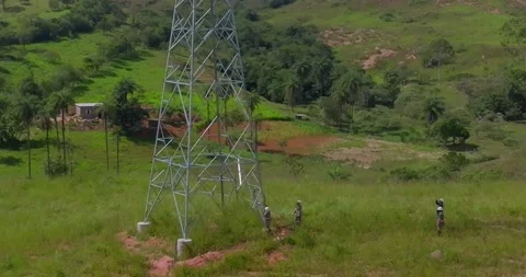 Utility workers inspecting electrical transmission tower in rural Brazil drone Stock Footage 335192330