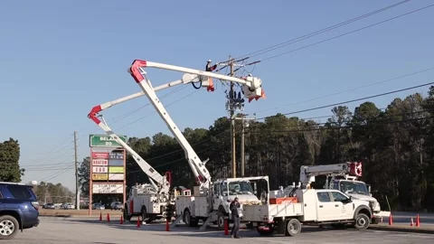 Utility workers on a lift working on power lines man on phone Stock Footage 149225518