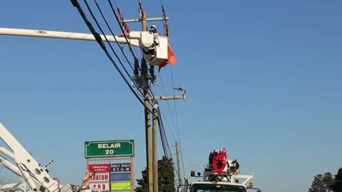 Utility workers on a lift working on power lines tilt down to traffic and pow Stock Footage 149226279