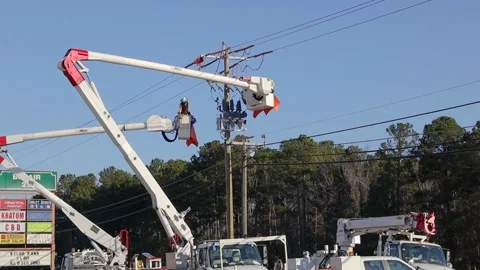 Utility workers on a lift working on power lines worker descends to the groun Stock Footage 149226318