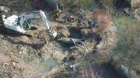 Utility workers repairing main water pipeline leak in pit Stock Footage 342816074