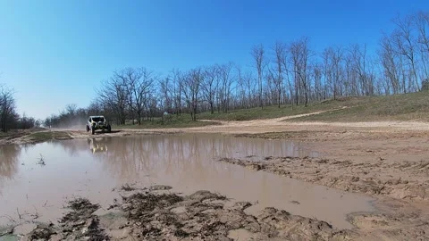 UTV Can-Am rides through 3 deep puddles Stock Footage 159468933