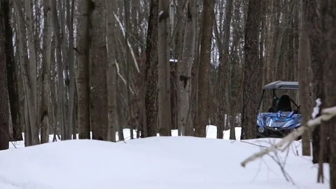 Utv side by side ripping through the woods in snow Stock Footage