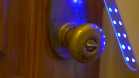 UV C sterilizer wand used on metal doorknob during the coronavirus pandemic Stock Footage 131685139