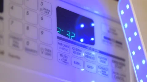 UV C sterilizer wand used microwave button panel during the coronavirus pandemic Stock Footage 131823083