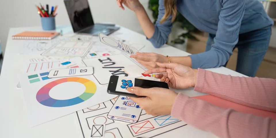 UX and UI Design Process. Designers analyzing mobile app prototypes and sketches Stock Photos