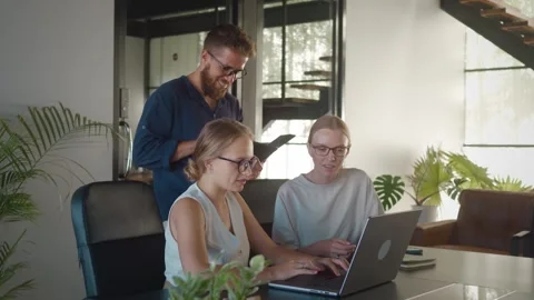 Ux designer and web developer, two women and man, are working together in Stock Footage 312120636