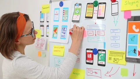 The UX designer is developing an interface for mobile phone applications. Stock Footage 122389222