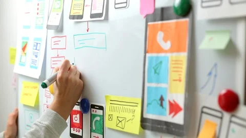 The UX designer is developing an interface for mobile phone applications. Stock Footage 122392142