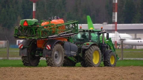 UX Super folded trailed sprayer attached to the tractor is driving away Stock Footage 240644959