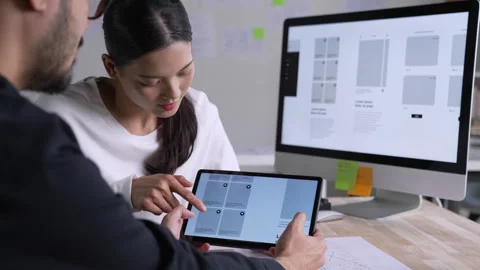 UX UI designer testing prototype on a tablet, discussing and brainstorming 库存影片 291551662