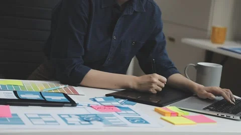 UX/UI designer working on wireframes for a website and mobile app prototype.. Stock Footage 309837502