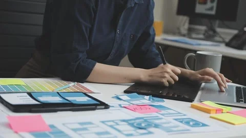 UX/UI designer working on wireframes for a website and mobile app prototype.. Stock Footage 309837511