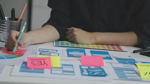 UX/UI designer working on wireframes for a website and mobile app prototype.. Stock Footage 309837610
