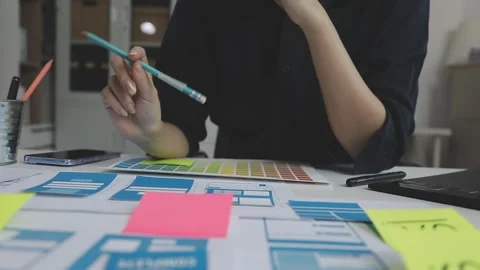 UX/UI designer working on wireframes for a website and mobile app prototype.. Stock Footage 309837621