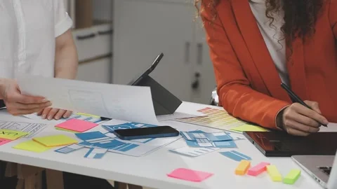 UX/UI designer working on wireframes for a website and mobile app prototype.. Stock Footage 309837636