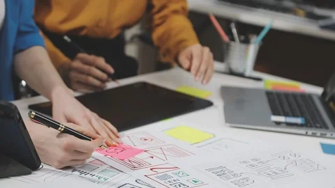UX/UI designer working on wireframes for a website and mobile app prototype.. Stock Footage 309838321