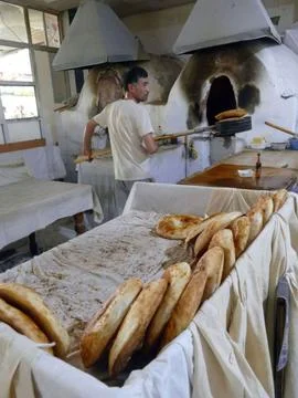 Uzbek baker preparing and baking traditional flatbread in a tandoor oven in.. Photos