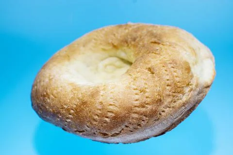 Uzbek flatbread on a blue background in levitation. Stock Photos