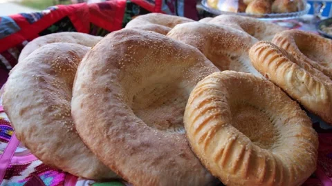 Uzbek flatbreads lie on a table decorated in national style. Stock Footage 262329927